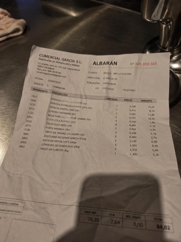 Foto real de un albarán de proveedor sobre la barra del bar